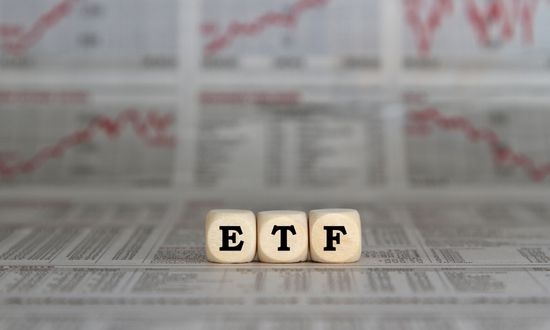 Investimenti ETF su giornale finanziario con grafici.