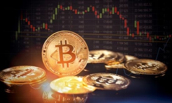 Monete Bitcoin con grafico di trading sullo sfondo.