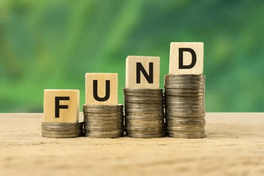 Monete impilate con blocchi che formano la parola "FUND".