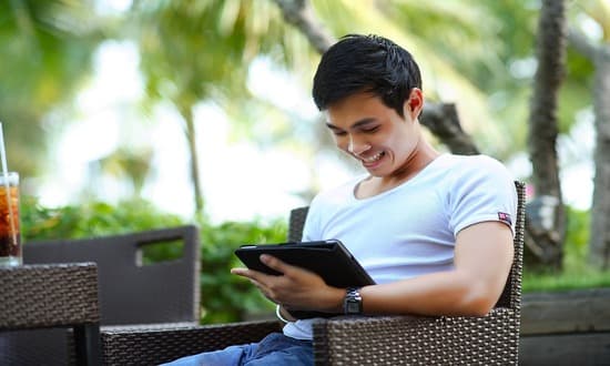 Uomo sorridente con tablet all'aperto.