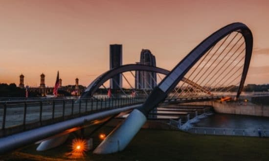 Ponte moderno al tramonto con skyline urbano.