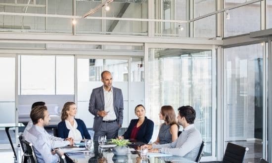 Riunione aziendale in ufficio moderno con team di lavoro.