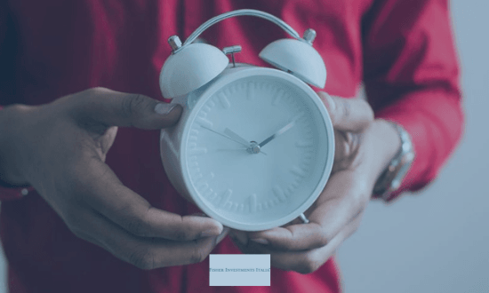 Persona che tiene una sveglia bianca in mano.