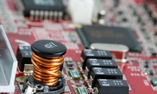 Circuito elettronico con componenti su scheda madre rossa.