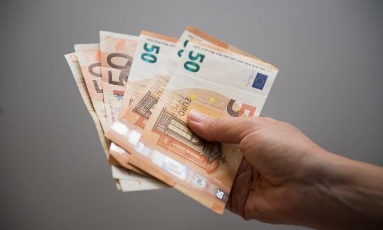 Mano che tiene banconote in euro.