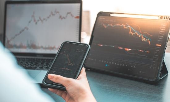 Grafici di trading su smartphone, tablet e laptop.