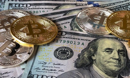 Bitcoin e dollari americani, criptovaluta e denaro tradizionale.