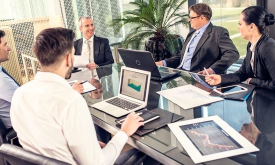 Riunione aziendale con dirigenti in ufficio moderno.