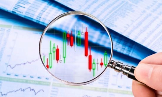 Grafico finanziario con lente d'ingrandimento e candele giapponesi.