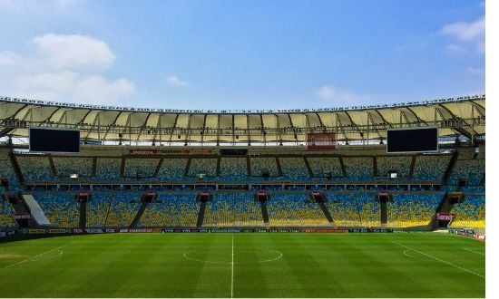Stadio di calcio vuoto con campo verde.