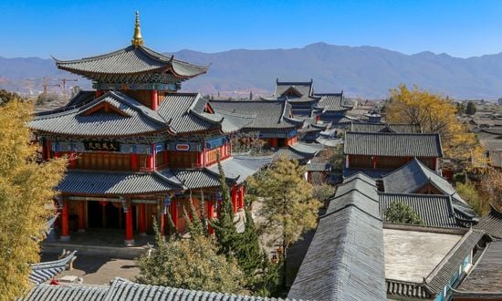 Tempio tradizionale cinese con montagne sullo sfondo.