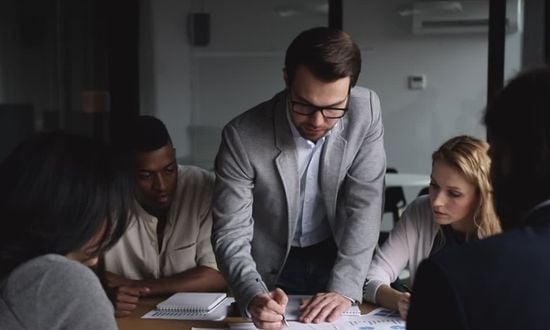 Riunione di lavoro in ufficio con team collaborativo.