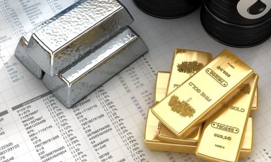 Lingotti d'oro e d'argento su foglio di calcolo finanziario.