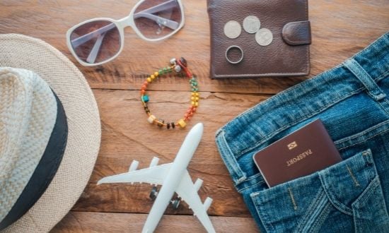 Accessori da viaggio: cappello, occhiali, portafoglio, passaporto, aereo giocattolo.