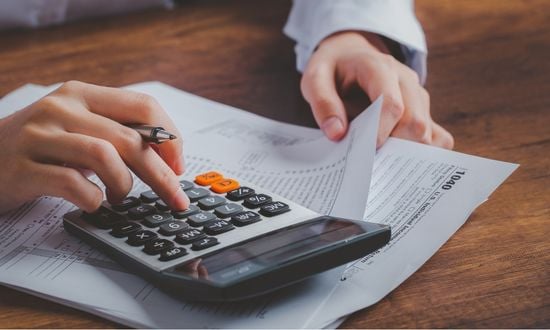 Calcolo delle tasse con calcolatrice e documenti fiscali.