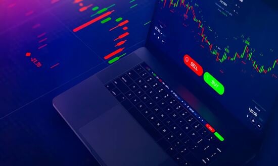 Grafico di trading su laptop con pulsanti compra e vendi.