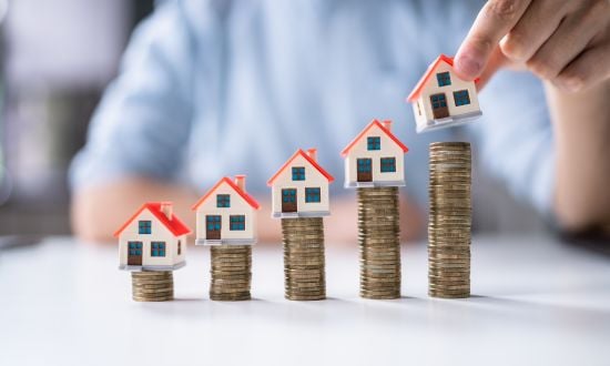 Crescita del valore immobiliare rappresentata con case e monete.