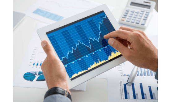 Analisi dati finanziari su tablet con grafici e calcolatrice.