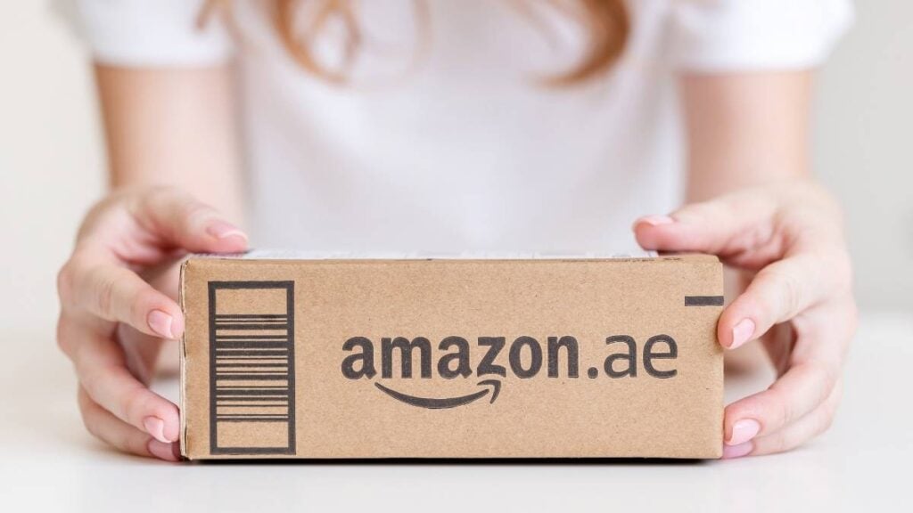donna che ha tra le mani un pacchetto con il logo amazon