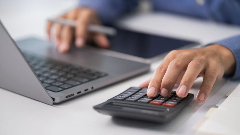 mani che usano calcolatrice e pc