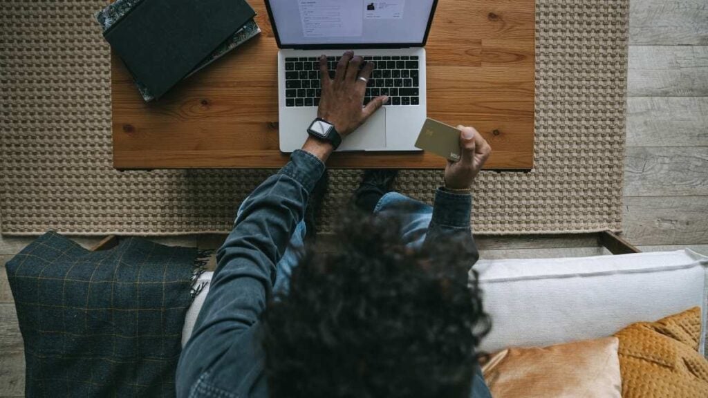 persona che naviga online su pc con carta di credito