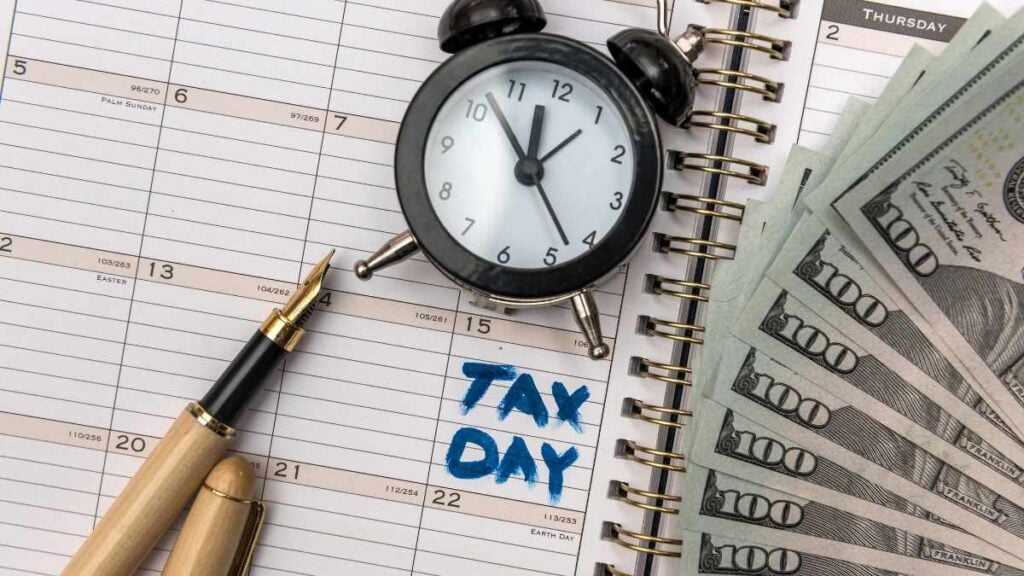 tax day con orologio penna e banconote