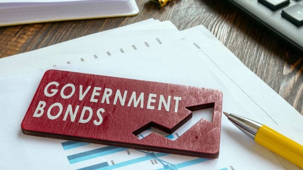 government bonds su fondo rosso con fogli e una penna